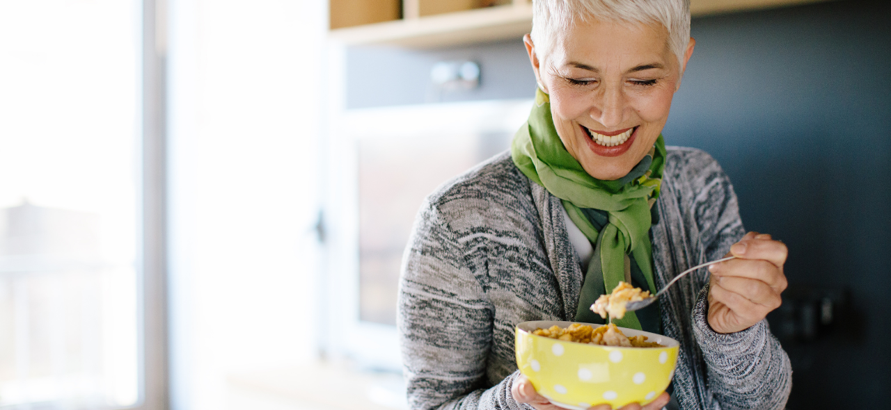 Woman smiling enjoying a bowl of cereals